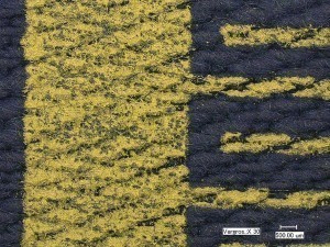 Abb. 3: Mikroskopische Aufnahme (30-fache Vergrößerung) des Siebdruckes einer Interdigitalstruktur auf Gewebe; Holm (links im Bild) und Kammelektroden (rechts im Bild)