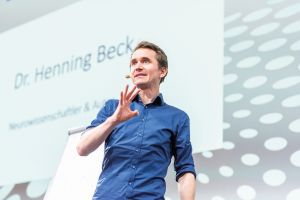 Unterhaltsam zeigt Dr. Henning Beck in seiner Rede, was wir der KI voraushaben – und wie wir das nutzen können