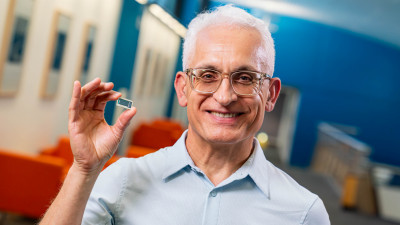 Hamid Azimi, Corporate Vice President und Leiter der Entwicklungsabteilung für Substrattechnologie, prsäentiert einen Chip mit Glassubstrat-Tiles