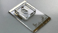 Bild des kompletten Sensors mit einer PDMS-Vertiefung von 100 μl Volumen für die Tropfenprüfung. Die gewünschte Flüssigkeitsprobe wird in die Vertiefung gegeben und inkubiert