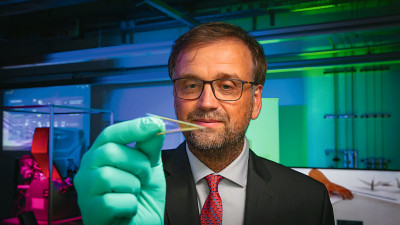 Prof. Dr. Oliver G. Schmidt ist Pionier bei der Erforschung und Entwicklung extrem kleiner, formbarer und flexibel einsetzbarer Mikrorobotik. Im Bild hält er eine ultraflexible, mikroelektronische Folie (Foto: Jacob Müller)