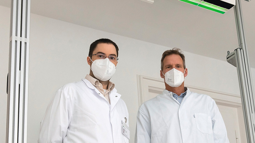 Die Entwickler Dr.med. Andreas Wieser und Prof. Dr. Christoph Haisch unter der Viren-Schutzwand (Foto: LMU Klinikum)