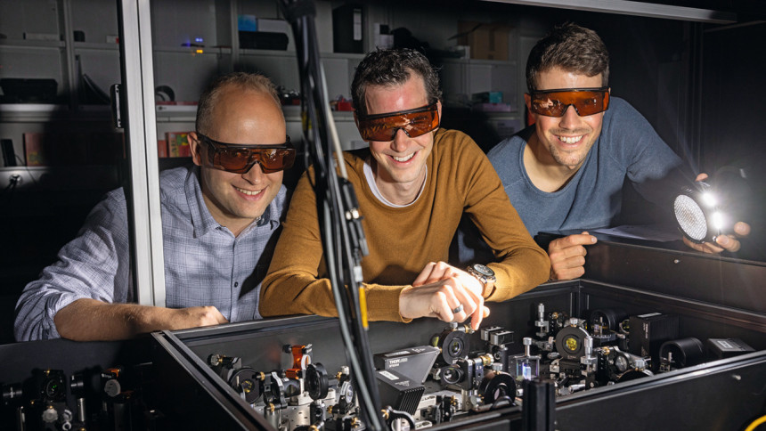Lysander Huberich (links), Teamleiter Bruno Schuler (Mitte) und Optik-Spezialist Jonas Allerbeck an der THz-Optik, die Pikosekunden-genaue Anregungsimpulse liefert